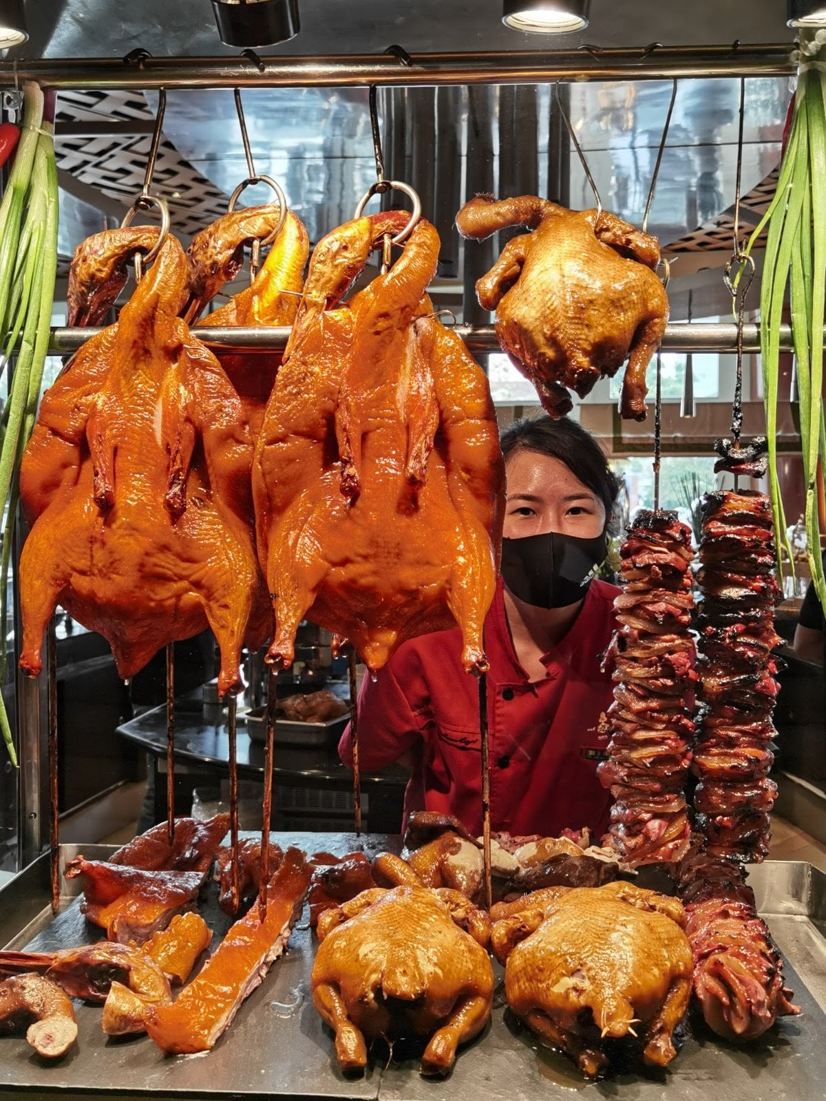 Whole ducks hanging on hooks above the charcoal oven.